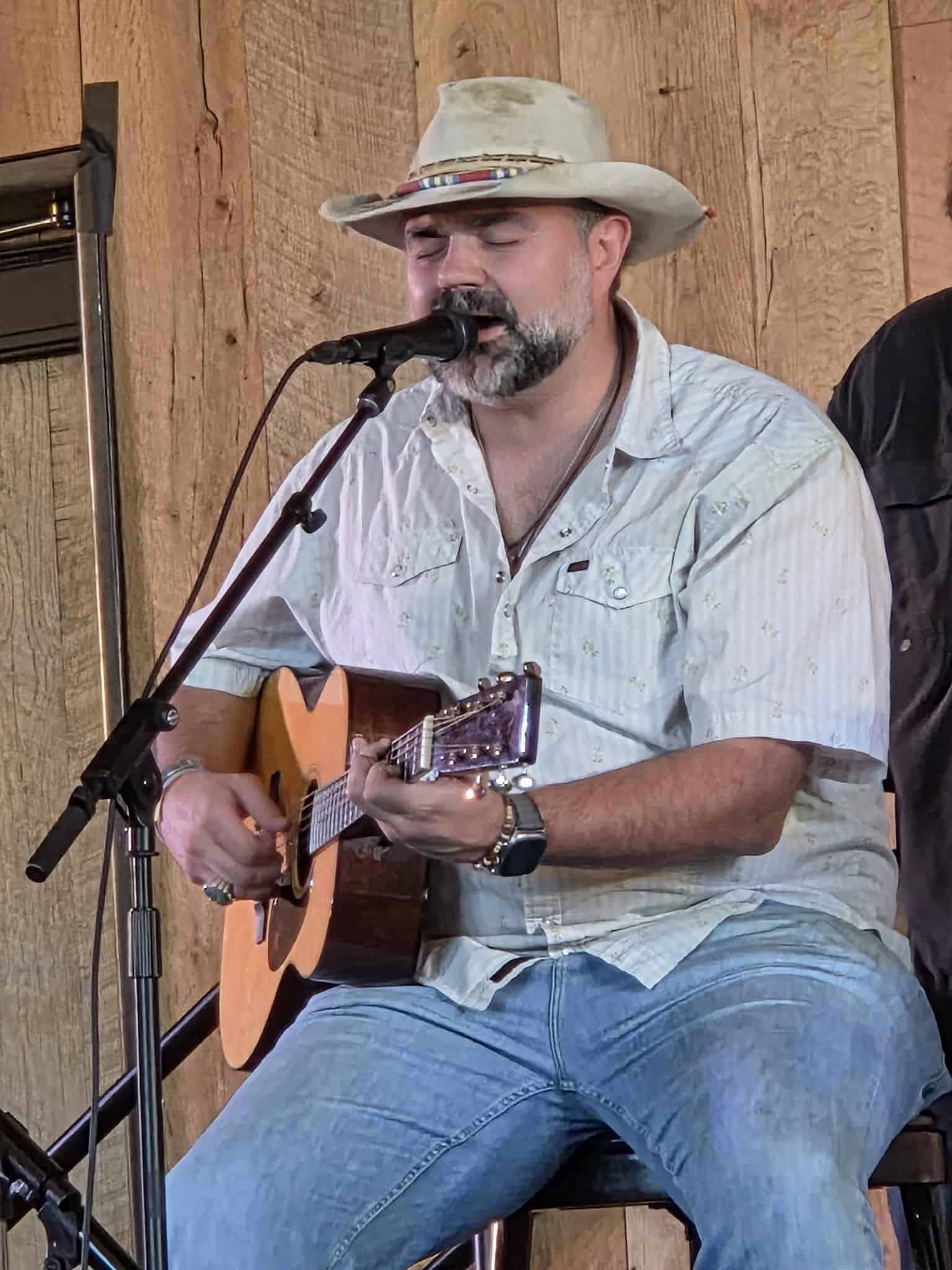 Django Walker performing on stage with a guitar